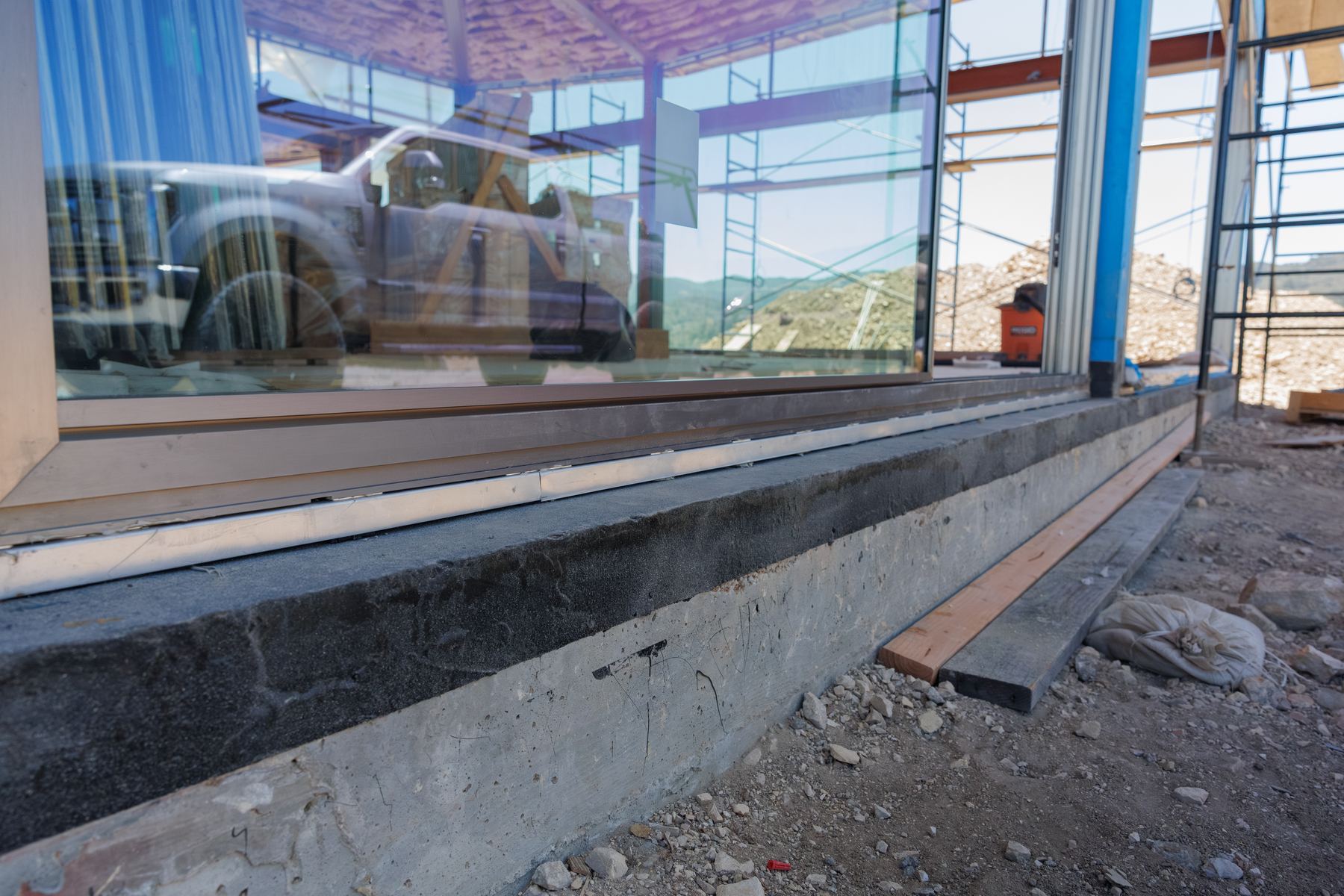 View along a large-format glass wall and its threshold during construction